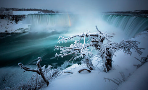 Niagara, Canada, this epic scene is made magical due to the hoarfrost crystals, formed when water vapour in the air has come into contact with the trees in the foreground, which are already below freezing point. Peter Izzard Photography Fine Art Print. 